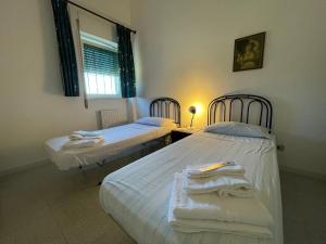 2 camas individuales en una habitación con ventana en Masseria Olga - Rural Coliving, en Turi