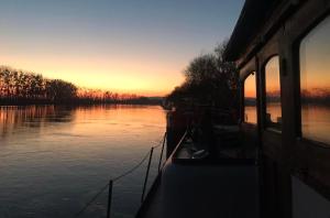 een boot is aangemeerd op een rivier bij zonsondergang bij Studio sur l'eau - Bateau Diva in Conflans-Sainte-Honorine