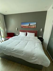 1 cama blanca grande en un dormitorio con silla roja en 8 Hotel & cafe en Bangkok