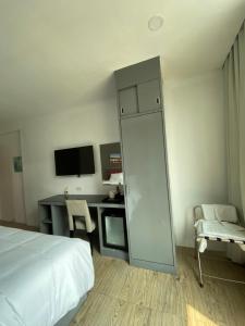 1 dormitorio con 1 cama y escritorio con ordenador en 8 Hotel & cafe en Bangkok