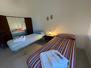 2 camas en una habitación pequeña con espejo en Masseria Olga - Rural Coliving, en Turi