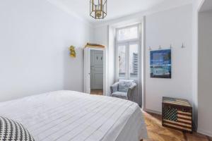 a white bedroom with a bed and a chair at Casa Elena Lago - Maggiore Estate by Ginin in Cannobio