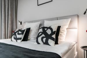 sypialnia z łóżkiem z czarno-białymi poduszkami w obiekcie VANTA Business Center w mieście Skawina