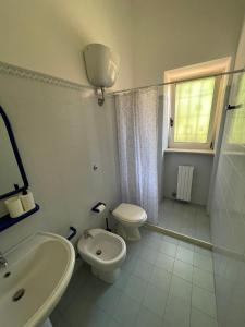 a white bathroom with a toilet and a sink at Masseria Olga - Rural Coliving in Turi