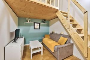 a living room with a couch and a staircase at Le cosy saint clair in Caluire-et-Cuire