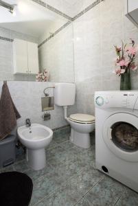 een badkamer met een wastafel en een wasmachine bij Cosy apartment near city centar and sea- Marina, Omiš in Omiš