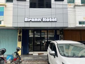 une voiture blanche garée devant une succursale d'hôtel dans l'établissement Brenn Hotel Semarang Mitra Reddoorz, à Semarang