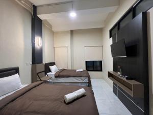 Cette chambre comprend 2 lits et une télévision à écran plat. dans l'établissement Brenn Hotel Semarang Mitra Reddoorz, à Semarang