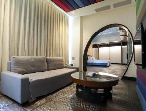 ein Wohnzimmer mit einem Sofa und einem Spiegel in der Unterkunft All-Ur Boutique Motel-Yi-Lan Branch in Yilan