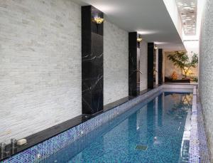 宜蘭市的住宿－歐遊國際連鎖精品旅館-宜蘭館，一座位于酒店带瓷砖墙的游泳池