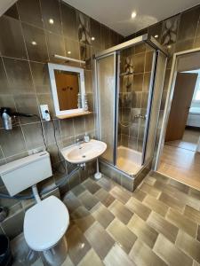 een badkamer met een toilet, een douche en een wastafel bij Nordseekrabbe in Holtgast