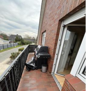 een grill op een veranda naast een gebouw bij Nordseekrabbe in Holtgast