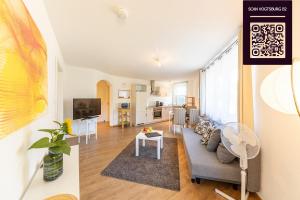 a living room with a couch and a table at Braviscasa - Ferienresidenz Haus am Bach Vogtsburg am Kaiserstuhl in Vogtsburg