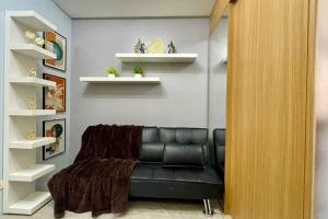 a black leather couch in a room with shelves at Condo Suite Near NAIA 3 and Mall of Asia in Manila