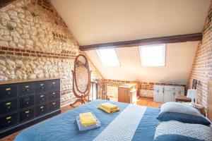 ein Schlafzimmer mit einem blauen Bett und einem Spiegel in der Unterkunft La Bicoque - Maison de pêcheur - Cour ext in Étretat