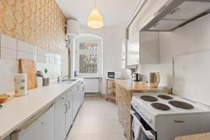 a kitchen with white counters and a stove top oven at primeflats - Apartments Schillerpark Berlin-Wedding in Berlin