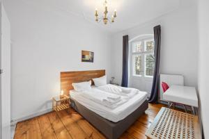 a bedroom with a bed and a desk and a window at primeflats - Apartments Schillerpark Berlin-Wedding in Berlin