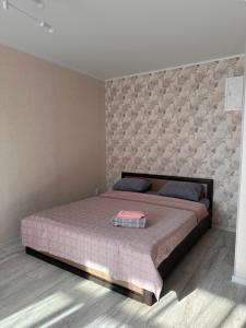 a bedroom with a large bed with a wall at Центр. Аль-Фараби 100 in Kostanay