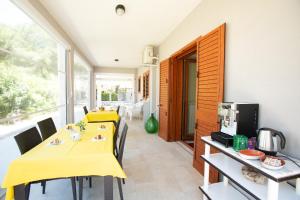 uma cozinha com duas mesas e uma toalha de mesa amarela em B&B Montedarena em Pulsano