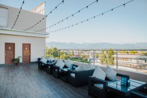 a room with couches and tables on a balcony at Nepalirika Hotel Biratchowk in Haraincha