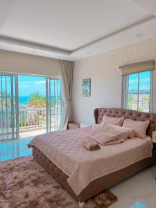 a bedroom with a bed with a view of the ocean at Villa 028 - Villa Novaworld Phan Thiet View Biển - 4BR - 3 Toilet in Phan Thiet