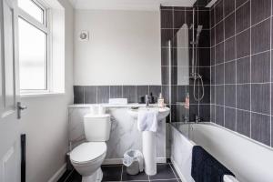 a bathroom with a toilet and a sink and a tub at Enjoy a spacious 3 BR home in Sunderland