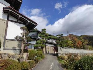 uma casa com uma estrada em frente em First floor Tatami room Local house stay- Vacation STAY 75395v em Hida
