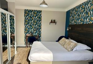 - une chambre avec un lit et un mur bleu dans l'établissement LOGIS Hôtel St Sylvestre, à Aldudes