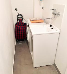 a suitcase is sitting next to a sink in a bathroom at cvr 3- Monolocale luminoso a due passi dalla Torre in Pisa +3 photos