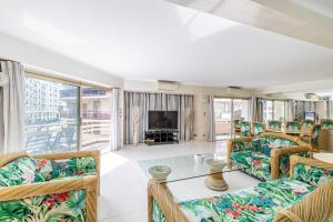 uma sala de estar com cadeiras, uma mesa e uma televisão em Central apartment with 3 bedrooms La Croisette em Cannes