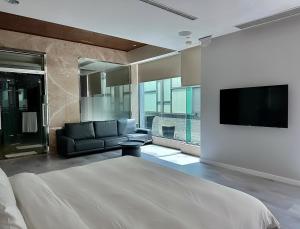 una camera con letto, divano e TV di All-Ur Boutique Motel-Ping Tung Branch a Città di Pingtung