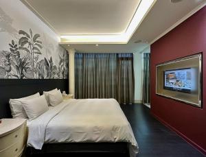 a bedroom with a large bed and a tv on a wall at All-Ur Boutique Motel-Ping Tung Branch in Pingtung City