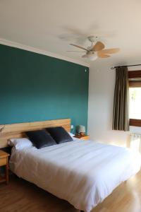 a bedroom with a large white bed with a blue wall at Hotel Balcó del Priorat in La Morera de Montsant