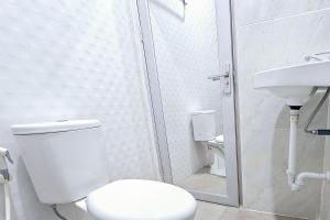e bagno con servizi igienici, doccia e lavandino. di Hotel Buana Express Mitra RedDoorz a Bojonegoro