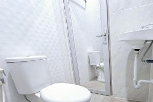 a bathroom with a toilet and a shower and a sink at Hotel Buana Express RedPartner in Bojonegoro