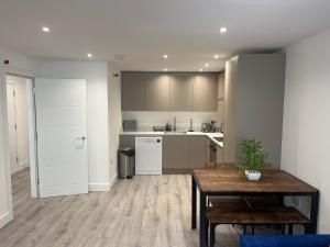 a kitchen with a table and a dining room at Modern 1 Bedroom Apartment Town Centre Camberley in Camberley