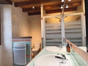 La salle de bains est pourvue de 2 lavabos et d'un miroir. dans l'établissement Le Relais de Saint-Preuil, The Originals Relais (Relais du Silence), à Saint-Preuil