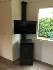 a living room with a fireplace with a flat screen tv at Charmante woning op rustig park met fietsen in Epe +13 photos