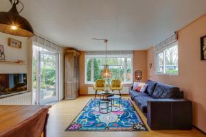 a living room with a blue couch and a rug at Chalet Louis met riante tuin en 3 slaapkamer 6p in Putten