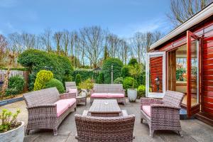 a patio with wicker chairs and a table at Chalet Louis met riante tuin en 3 slaapkamer 6p in Putten