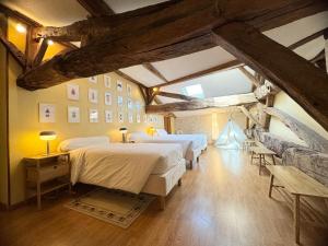 a bedroom with two beds in a room with beams at Le Relais de Saint-Preuil, The Originals Relais (Relais du Silence) in Saint-Preuil