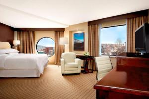 Cette chambre comprend un lit et une grande fenêtre. dans l'établissement Sheraton Hotel Newfoundland, à Saint-Jean