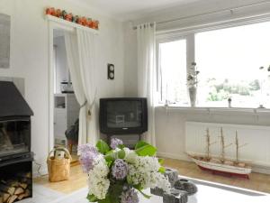 a living room with a tv and a vase of flowers at Holiday Home Sörkila in Lysekil