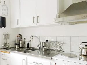 a kitchen with white cabinets and a sink at Holiday Home Sörkila in Lysekil