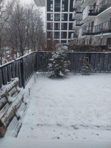 a yard covered in snow next to a fence at Słońce Bemowa in Warsaw