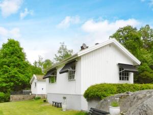a white house with windows and a yard at Holiday Home Sörkila in Lysekil