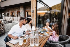 a group of people sitting at a table at a restaurant at Hofgut Wagrain Apartment & Lifestyle Resort in Wagrain