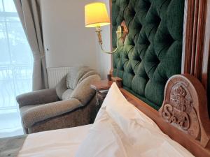 a bedroom with a bed and a chair and a lamp at Pegasa Pils Spa Hotel in Jūrmala