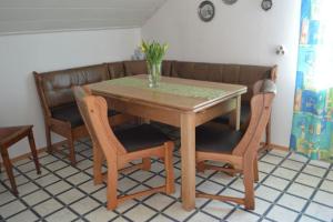 a wooden table with two chairs and a vase on it at Almer Ferienwohnung in Brilon