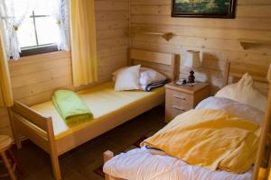 Słoneczne Ranczo - Domki في كرينيتا مورسكا: غرفة نوم بسريرين في كابينة خشب